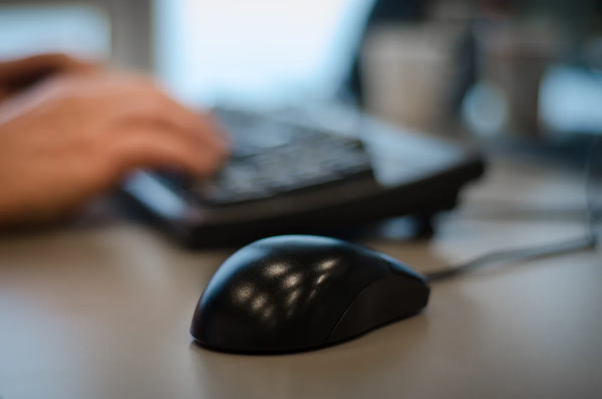Zzp'er berekent AOV-premie online via laptop met computermuis op bureau