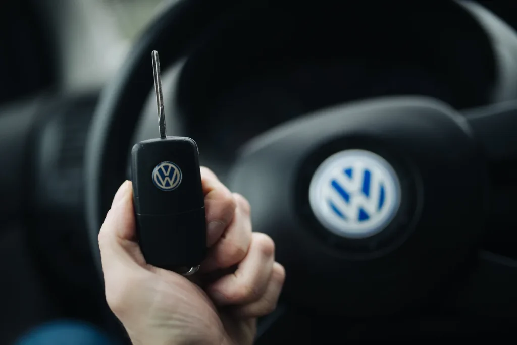 Man houdt autosleutels vast met stuur op de achtergrond — auto lenen of uitlenen en verzekering 2026