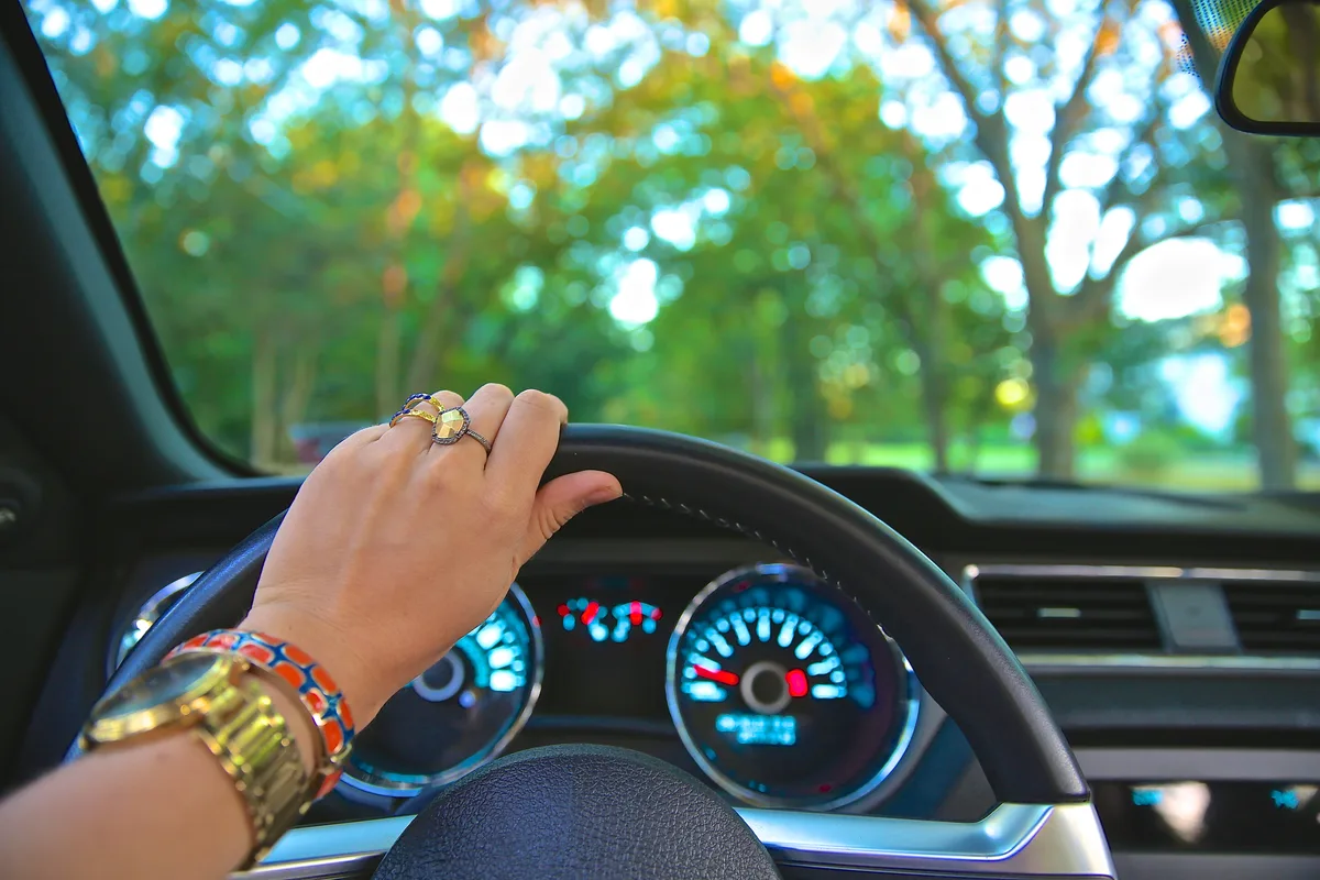 Vrouwenhand op stuurwiel van auto — autoverzekering tips voor vrouwen 2026