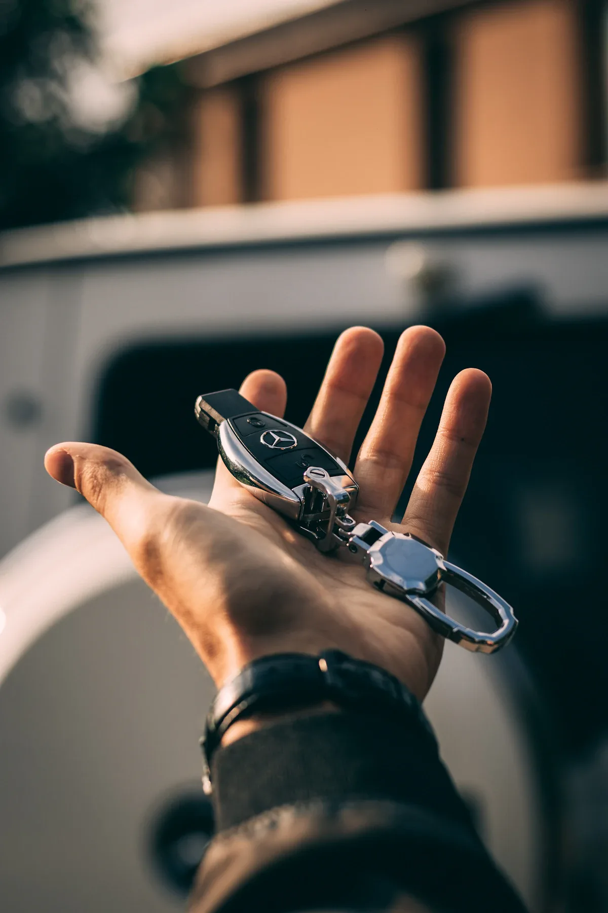 Persoon houdt sleutelhangers van een auto vast — autoverzekering leaseauto vs eigen auto vergelijking 2026