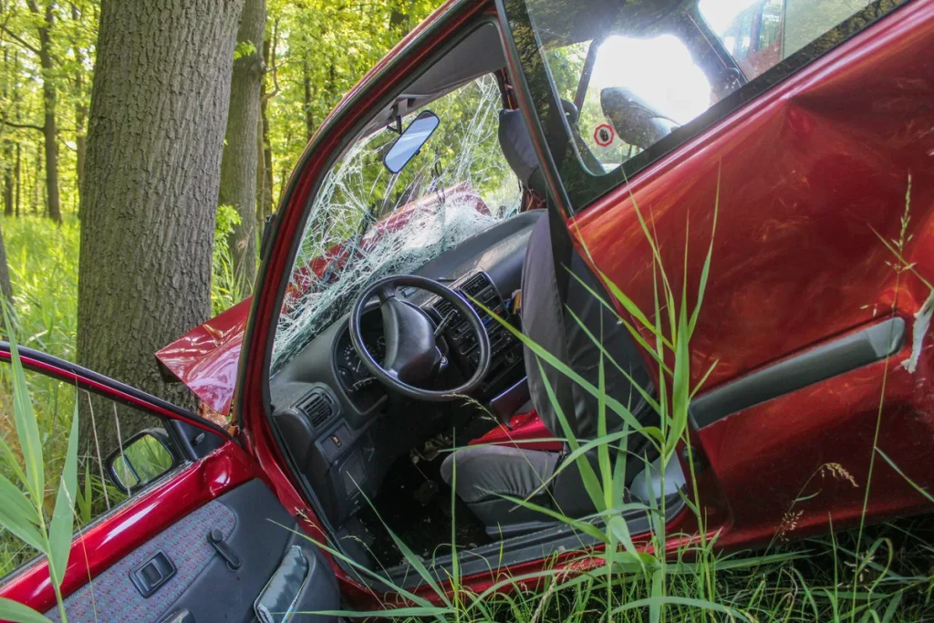 Rode auto met zware schade na aanrijding met boom — illustratie van het belang van een goede autoverzekering