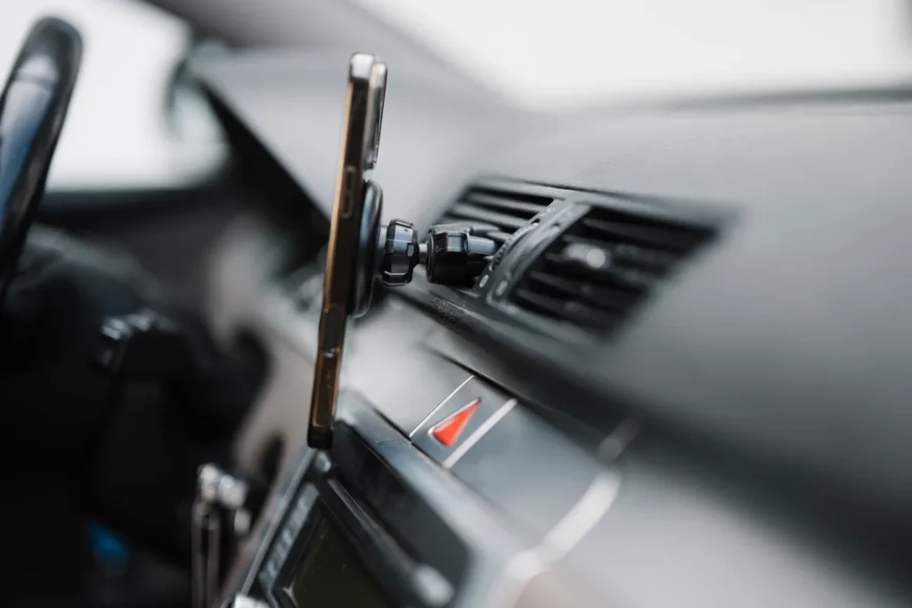 Smartphone gemonteerd op het dashboard van een rijdende auto — symbool voor in-app autoverzekering-simulatie via de verzekeraar-app