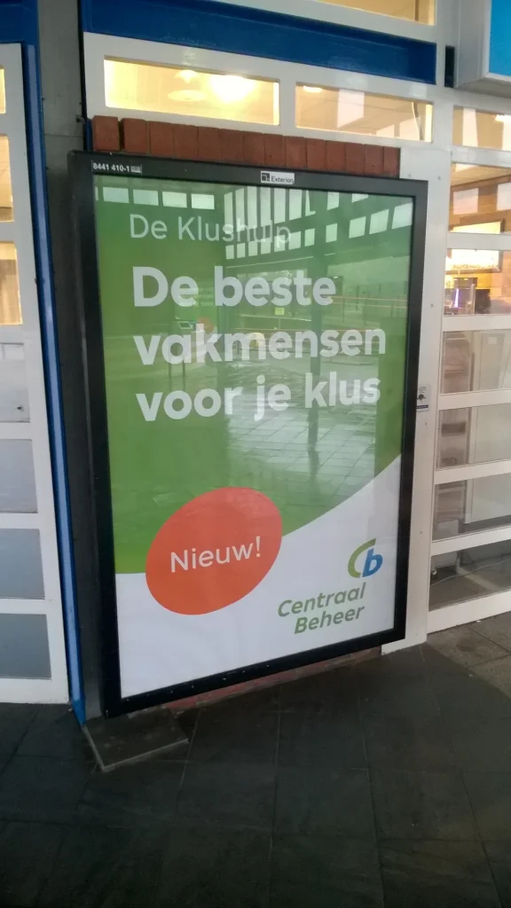 Centraal Beheer advertentie op station Heerenveen — autoverzekering via Achmea-label