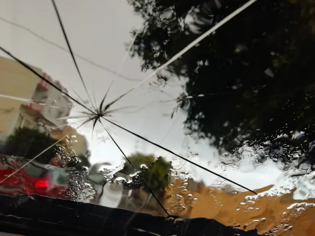 Barst in voorruit van auto — lange scheur door veiligheidsglas zichtbaar vanuit bestuurderszijde