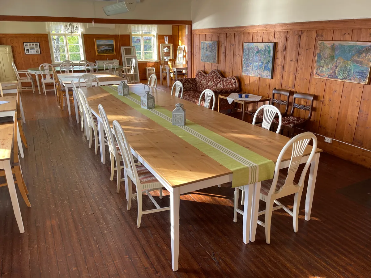 Interieur van een bed and breakfast eetzaal met houten meubels en gedekte tafels