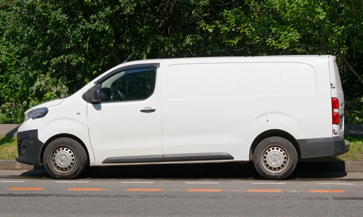 Witte bedrijfsauto bestelauto geparkeerd langs de weg — bedrijfsauto verzekering berekenen 2026