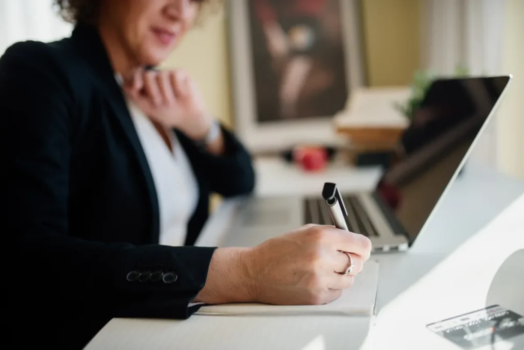 Adviseur neemt notities op laptop tijdens zakelijke vergadering — beroepsaansprakelijkheid voor consultants