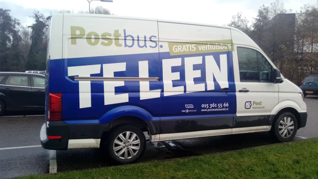 Witte verhuisbus geparkeerd op straat in Den Haag — bestelbus huren voor verhuizing
