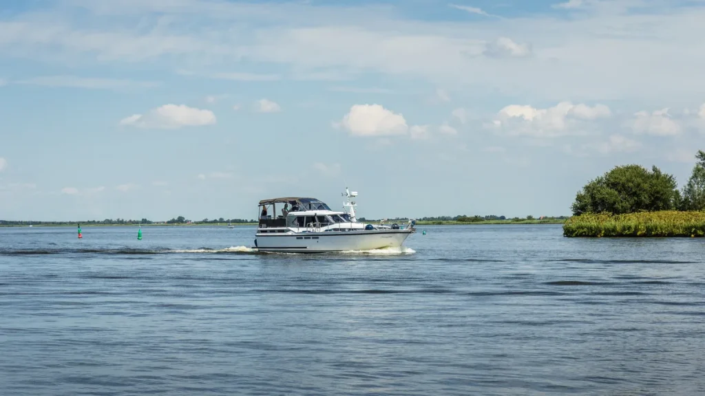 Witte motorboot vaart over Nederlands binnenwater, voorbeeld van een vaartuig dat een bootverzekering nodig heeft