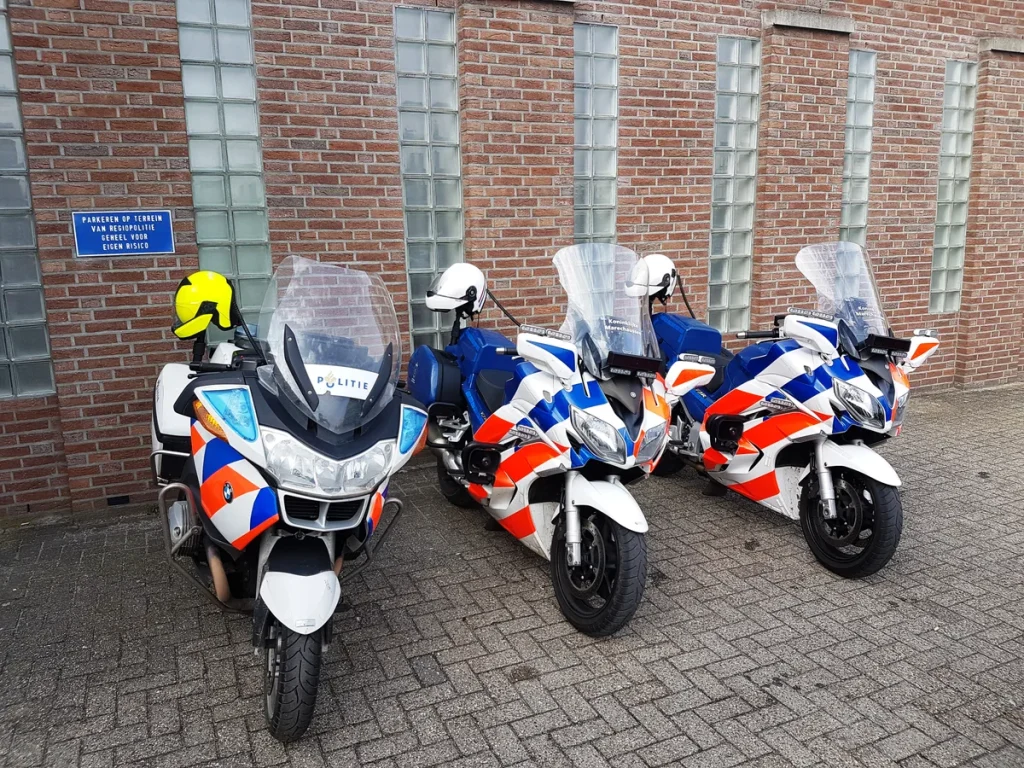 Nederlandse politiemotoren geparkeerd naast een gebouw, motorverzekering Nederland 2026
