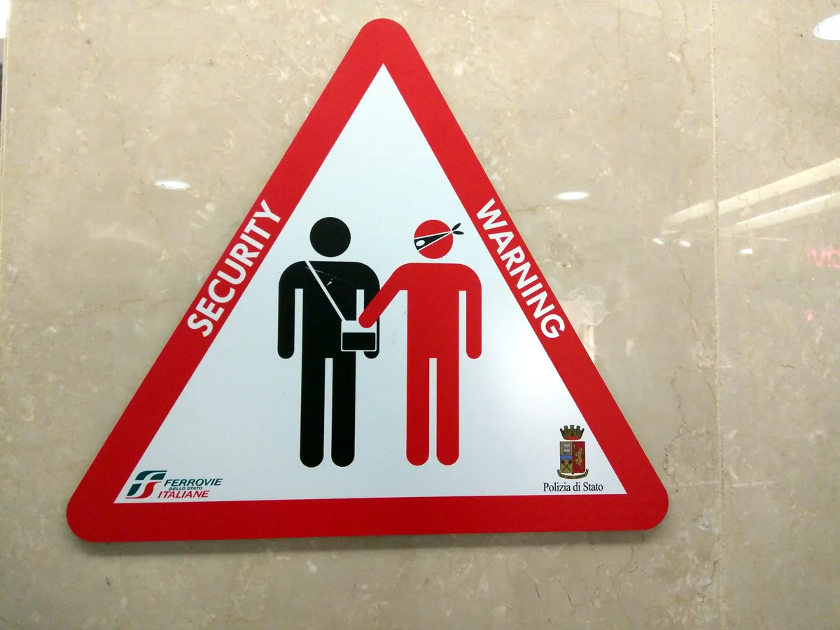 Zakkenroller-waarschuwingsbord op Italiaans treinstation — diefstal buitenland reisverzekering