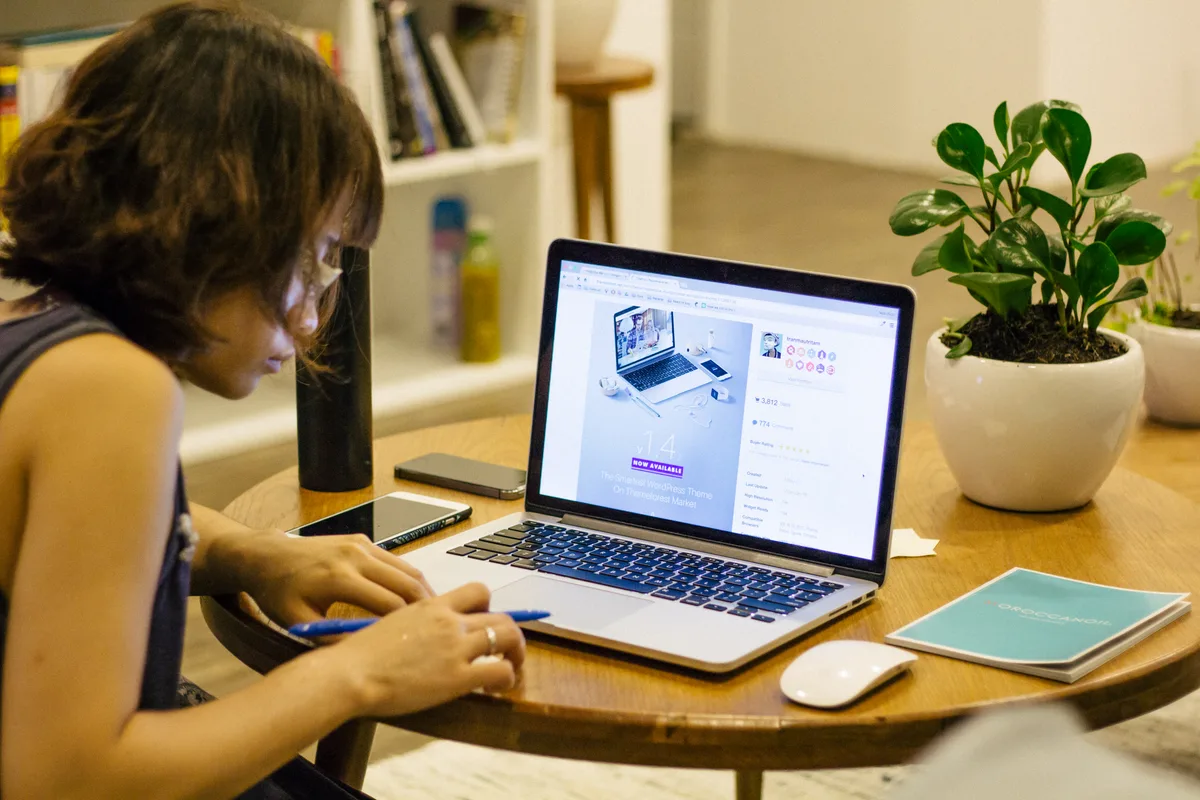Vrouw maakt aantekeningen aan koffietafel met laptop — ZZP eindejaars-checklist verzekeringen 2026