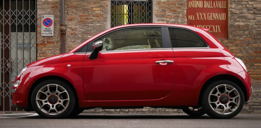 Rode Fiat 500 moderne hatch geparkeerd in Emilia-Romagna, Italië — autoverzekering Fiat 500