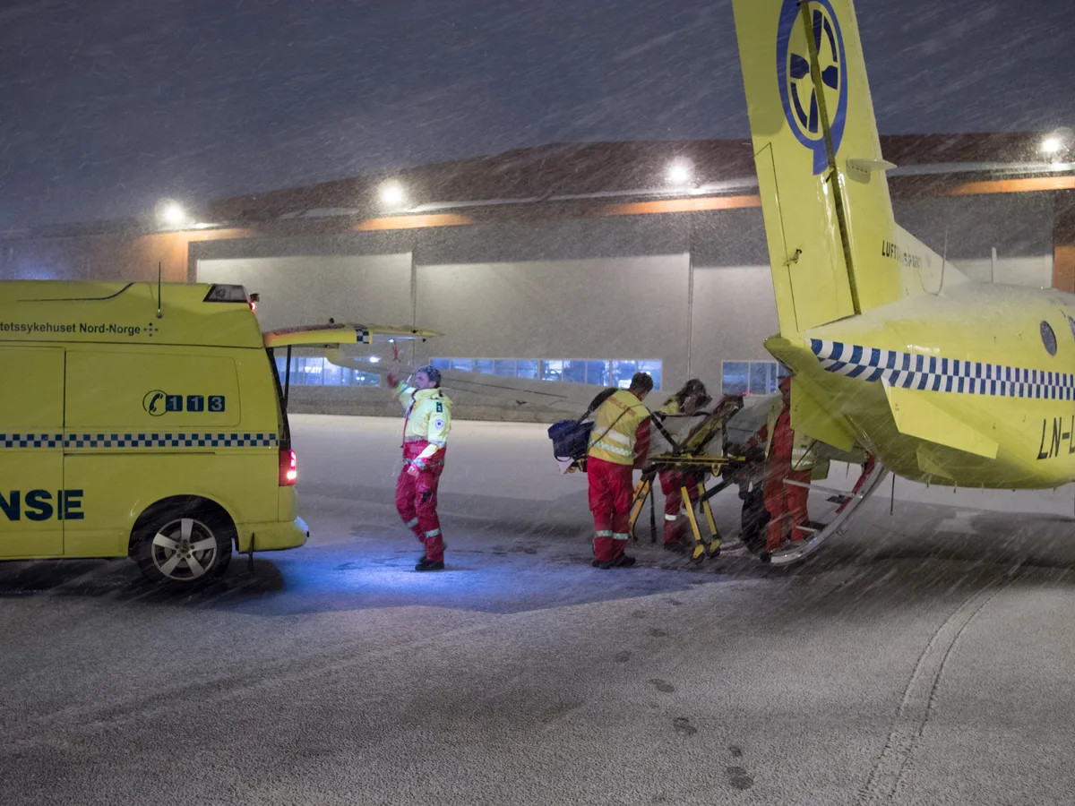 Medisch personeel laadt patient op brancard in ambulancevliegtuig voor medische repatriering