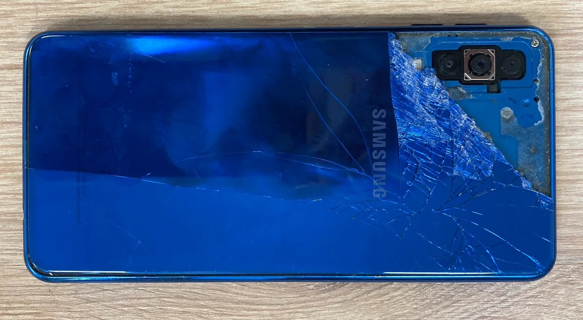 Gebroken Samsung Galaxy smartphone met verbrijzeld glas achterkant — typische valschade die een gadgetverzekering dekt