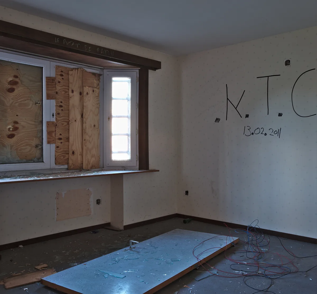 Verlaten woning in Doel met kapotte ramen en glassplinters op de vloer - glasschade die een glasverzekering dekt