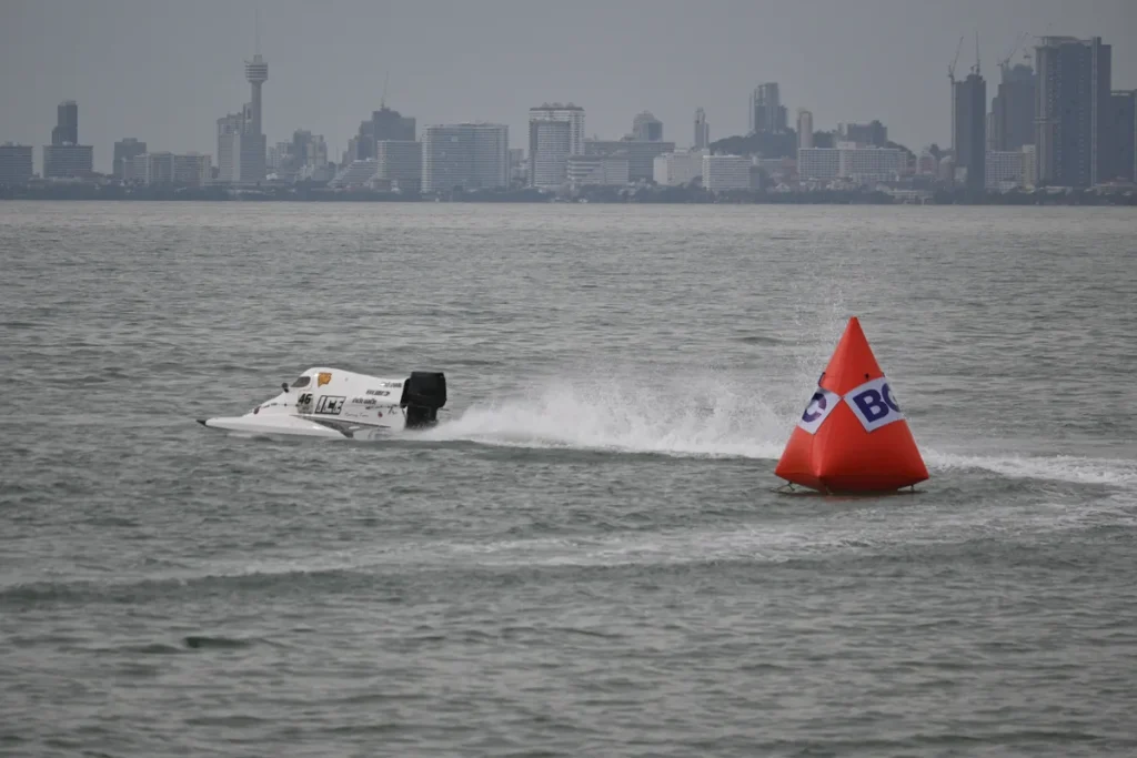 Snelle speedboot vaart met hoge snelheid langs een oranje boei op ruig water — speedbootverzekering 2026