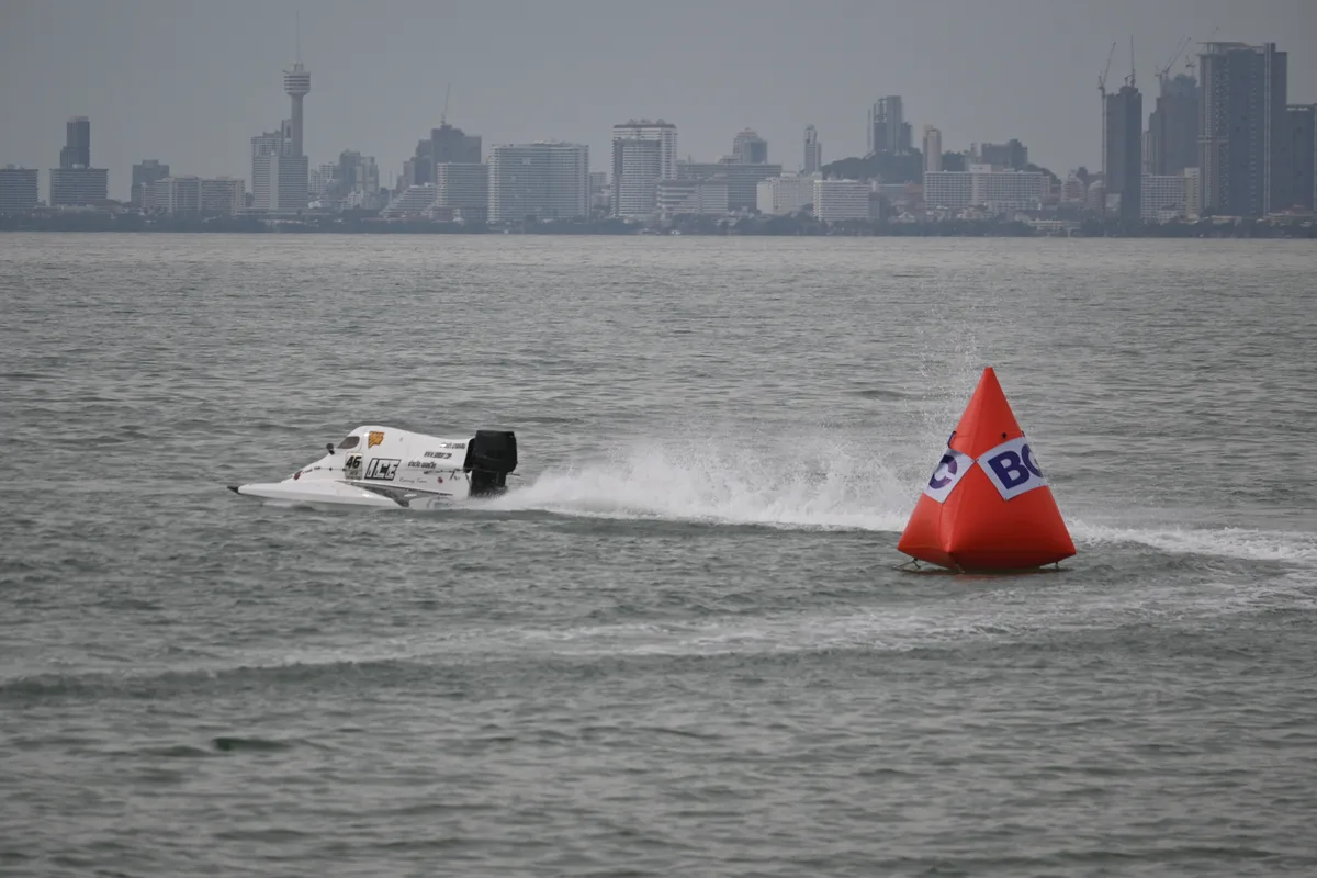 Snelle speedboot vaart met hoge snelheid langs een oranje boei op ruig water — speedbootverzekering 2026