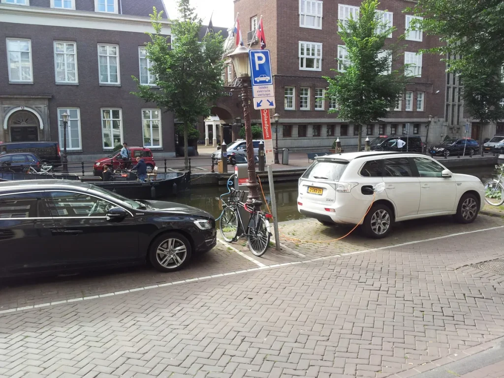 Plug-in hybride auto's Volvo V60 en Mitsubishi Outlander PHEV aan laadstation Amsterdam