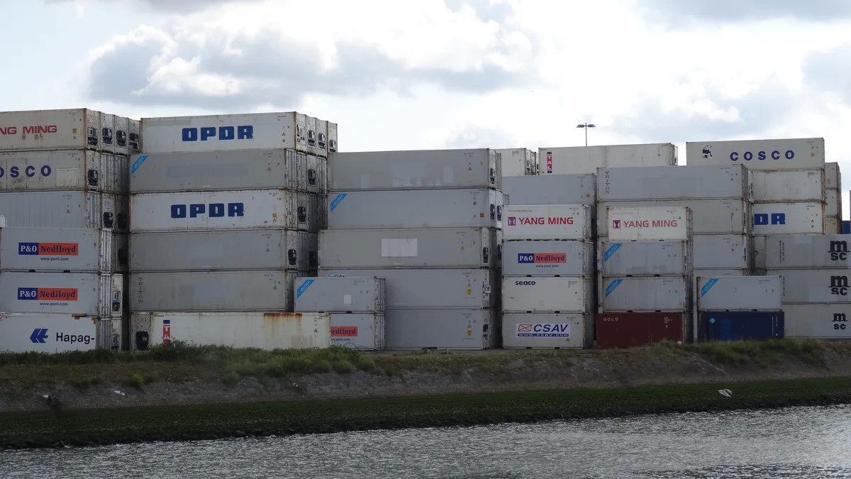 Gestapelde scheepscontainers in de haven van Rotterdam — import verzekering voor goederentransport