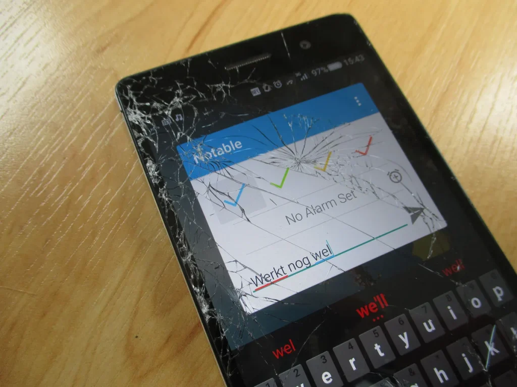 Gebarsten scherm van een Huawei smartphone na een val — typische schade die inboedelverzekering niet dekt buitenshuis