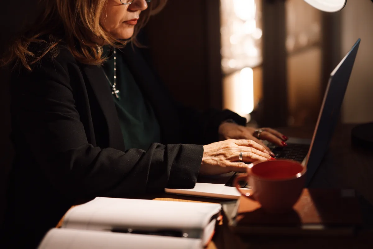 Vrouw werkt op laptop aan thuiswerkplek — inboedelverzekering en zakelijke apparatuur thuis