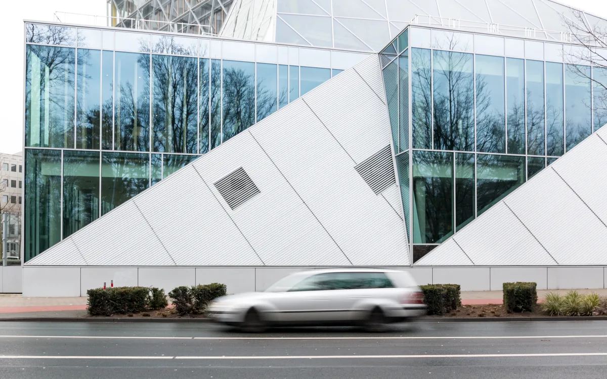 Auto rijdend langs verzekeringsgebouw LVM — illustratie bij Interpolis inzittendenverzekering 2026