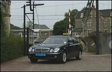 Zwarte Mercedes-Benz taxi met taxilamp op het dak in een Nederlandse straat