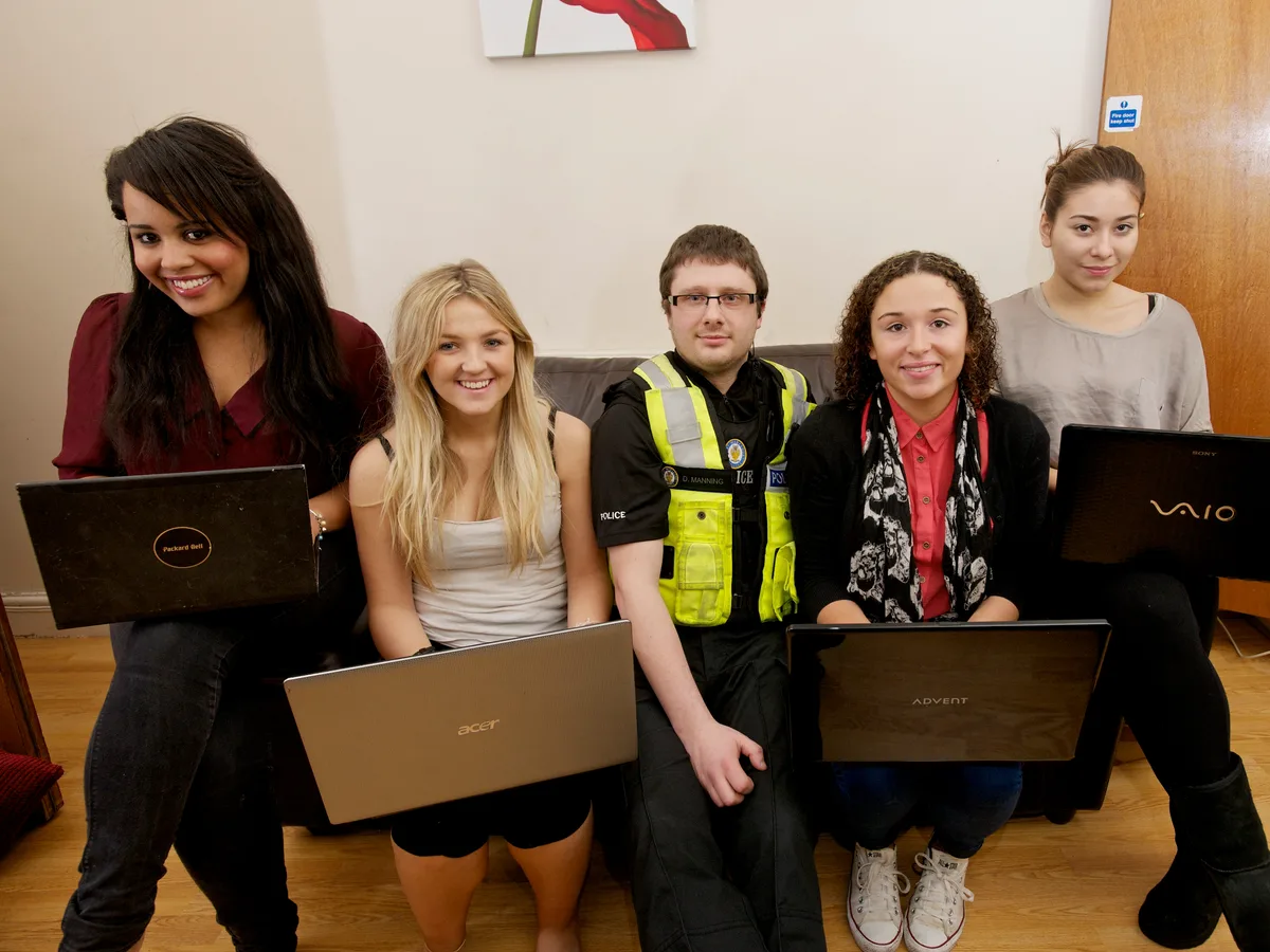 Student laptop veiligheid - politieagent en student met laptop bespreken beveiliging en diefstalpreventie