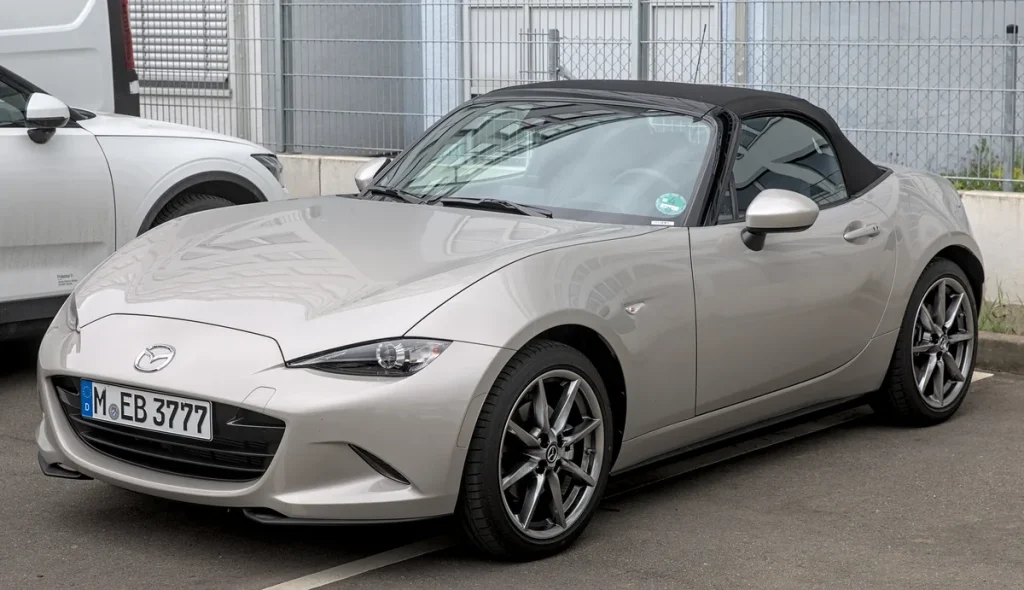 Zilvergrijze Mazda MX-5 ND roadster cabriolet geparkeerd, zijaanzicht met gesloten softtop