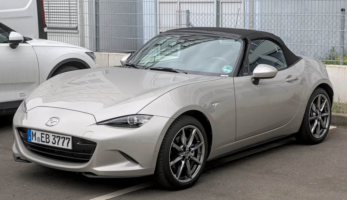 Zilvergrijze Mazda MX-5 ND roadster cabriolet geparkeerd, zijaanzicht met gesloten softtop