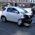 Wit personenauto met zwaar frontale schade na aanrijding in Helsinki — illustratie negatieve schadevrije jaren