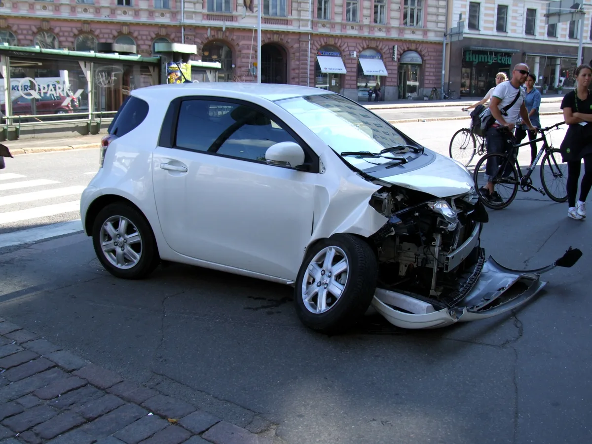 Wit personenauto met zwaar frontale schade na aanrijding in Helsinki — illustratie negatieve schadevrije jaren