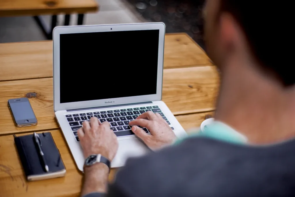 ZZP'er typt op laptop en gebruikt een online verzekeringscalculator om zijn premies te berekenen