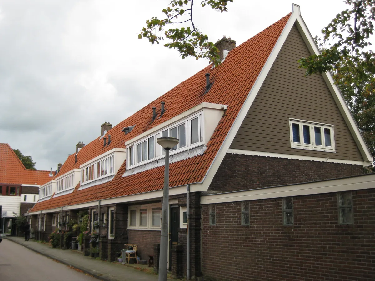 Rij Nederlandse rijtjeshuizen met rode pannendaken, symbool voor hypotheek en overlijdensrisicoverzekering
