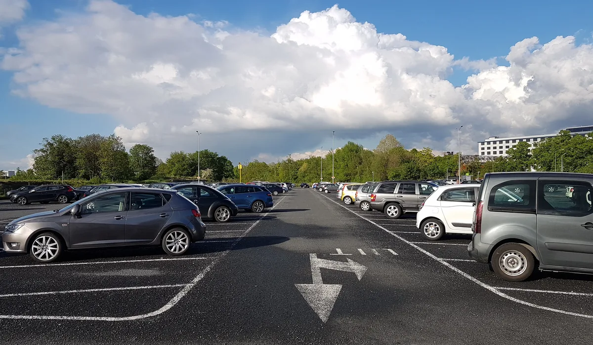 Meerdere geparkeerde auto's op een parkeerterrein in Nederland — symbool voor gezinnen met meerdere voertuigen