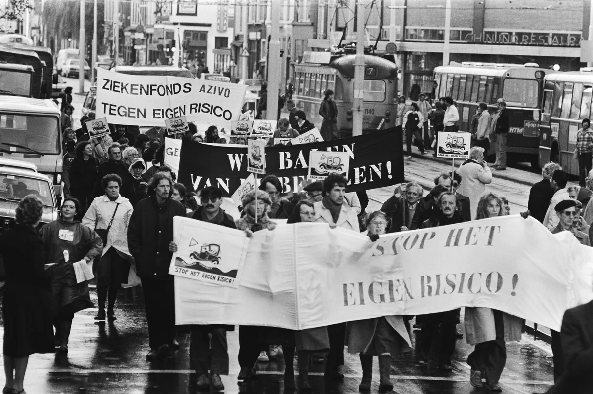 Demonstranten met spandoeken 'Stop het eigen risico' en 'Ziekenfonds AZIVO tegen eigen risico' in Nederlandse straat