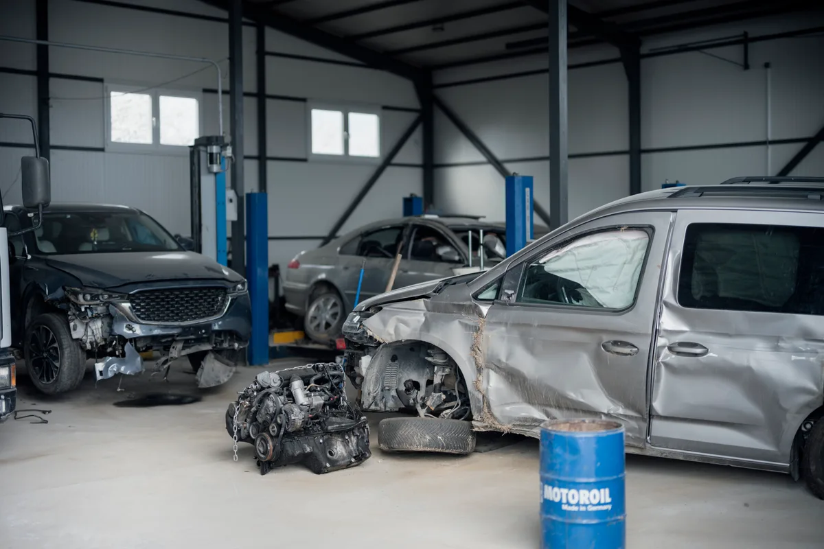Beschadigde auto's in een reparatiewerkplaats — schadeafhandeling autoverzekering Promovendum 2026
