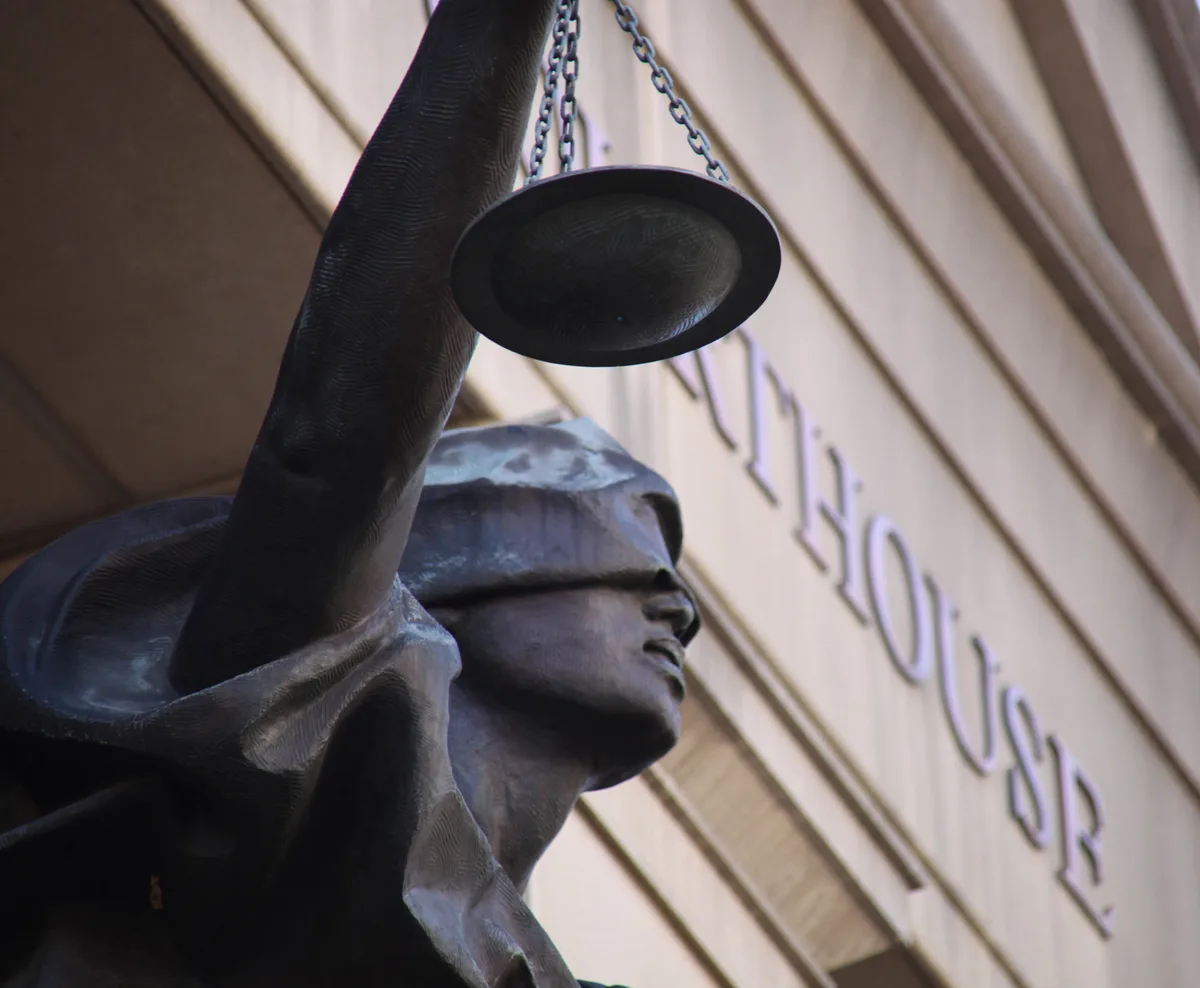 Standbeeld van Vrouwe Justitia met weegschaal voor een courthouse — symbool van juridische hulp via rechtsbijstandverzekering