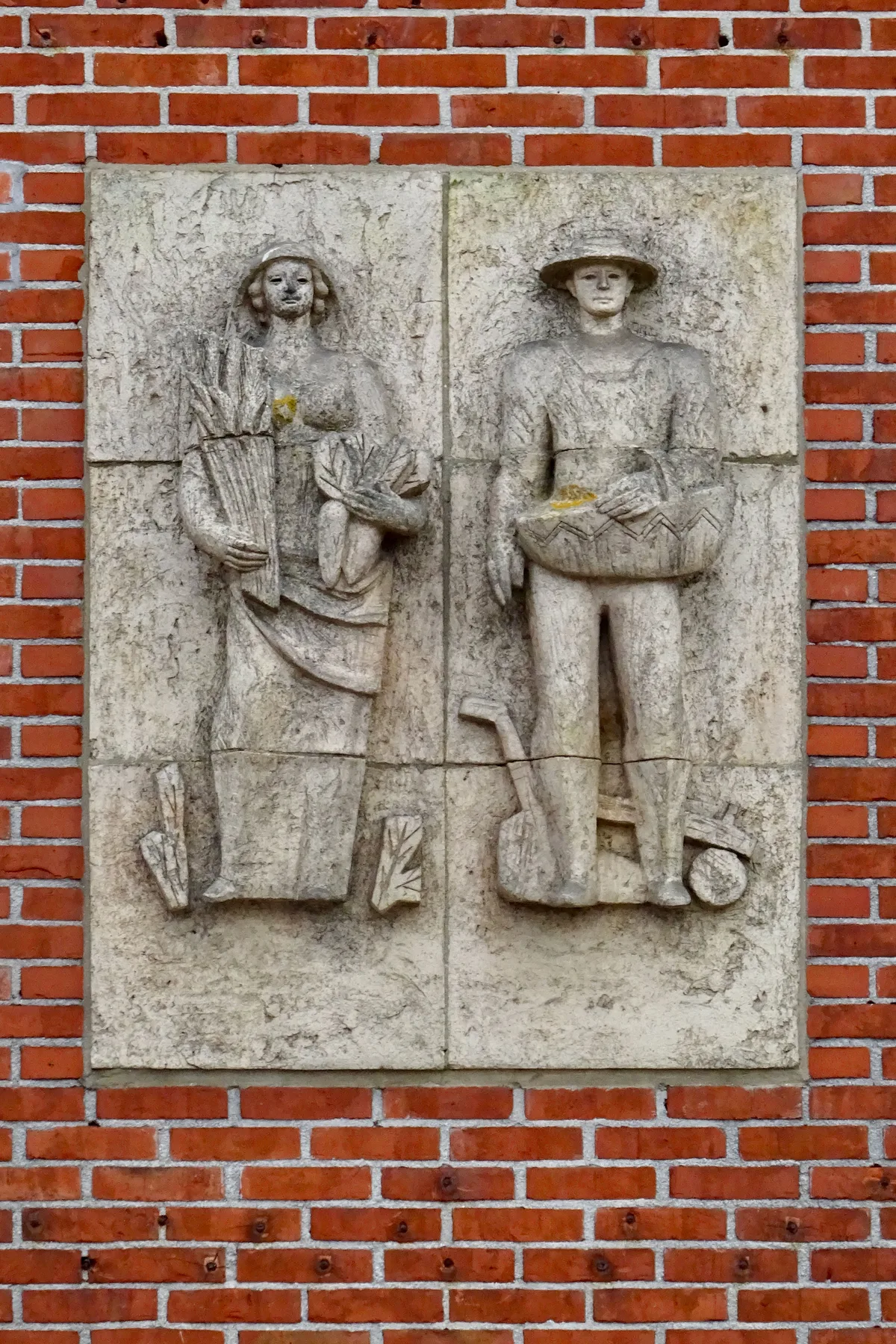 Reliefplaquette op de Coöperatieve Landbouwbank in Beilen met boerin en boer, symbool voor agrarische verzekering