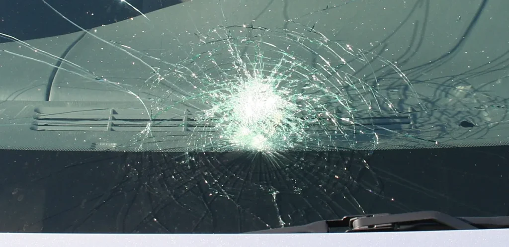 Voorruit auto met spinnenweb-barsten door steenslag — ster in ruit glasschade