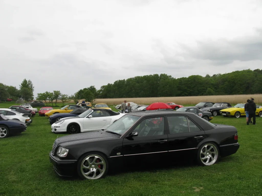 Zwarte Mercedes-Benz 500E W124 youngtimer op een klassieke autoshow — tweedehands Mercedes verzekeren