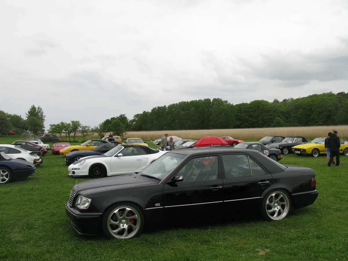 Zwarte Mercedes-Benz 500E W124 youngtimer op een klassieke autoshow — tweedehands Mercedes verzekeren