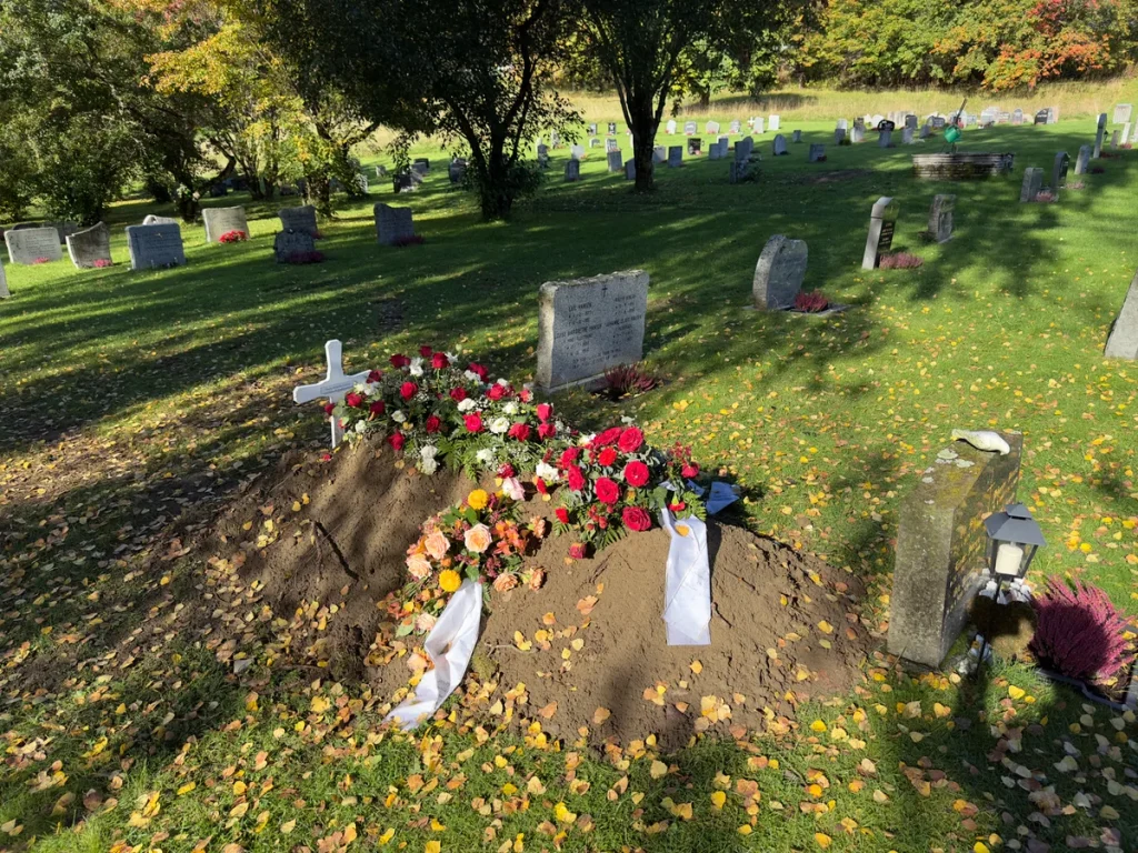 Vers graf met bloemen en kransen op begraafplaats, passend bij uitvaartverzekering en uitvaartkosten
