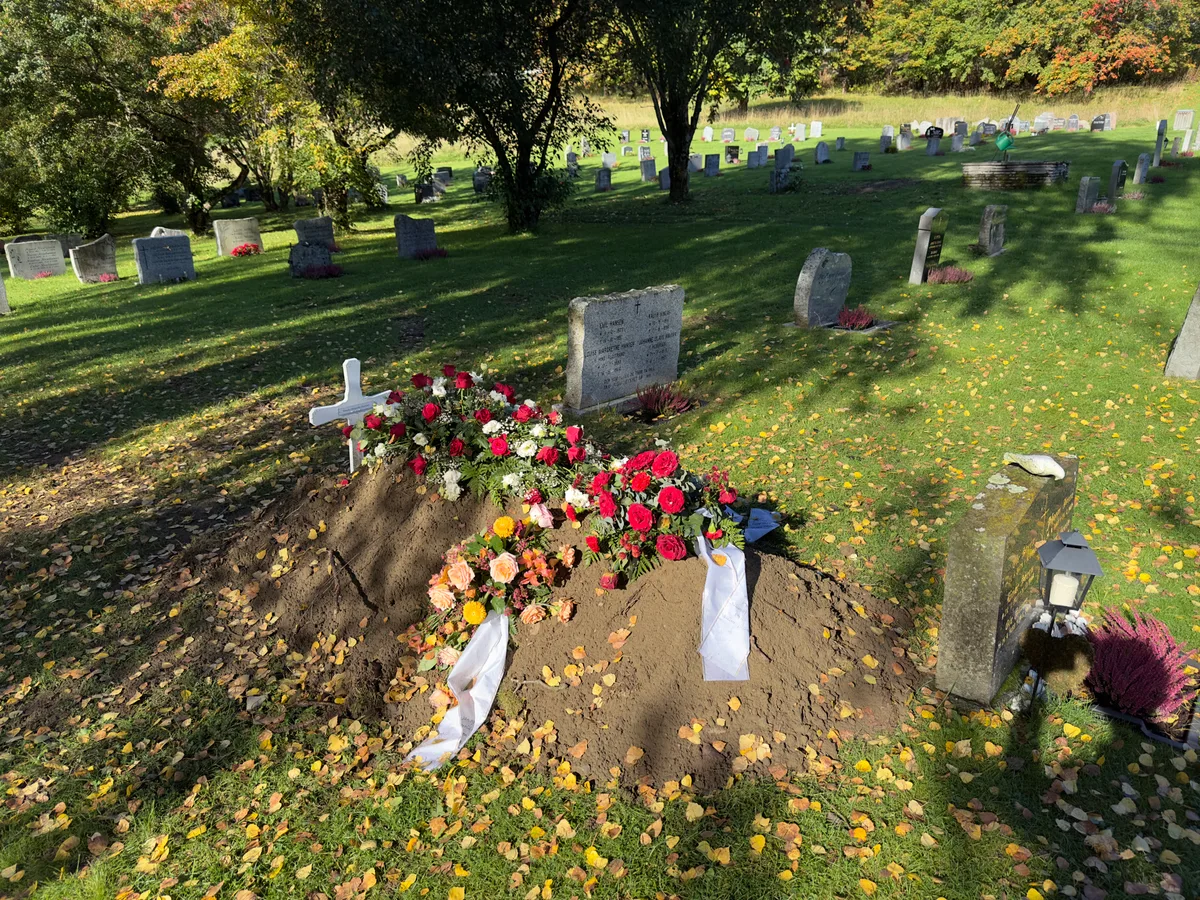 Vers graf met bloemen en kransen op begraafplaats, passend bij uitvaartverzekering en uitvaartkosten