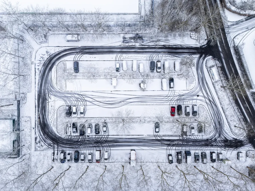 Parkeerterrein met meerdere auto's geparkeerd — twee auto's op één naam verzekeren