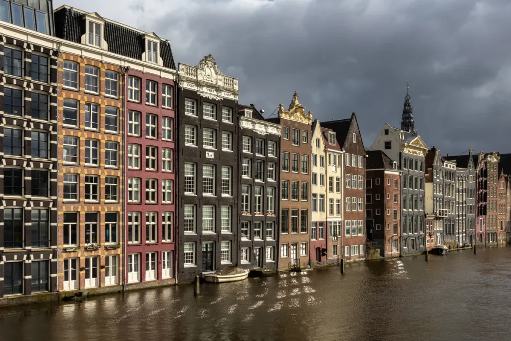 Kleurrijke grachtenpanden aan de Damrak in Amsterdam, typisch voor de Amsterdamse binnenstad