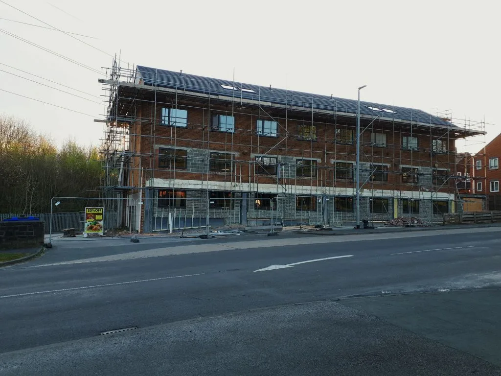 Woongebouw in aanbouw met steigers rondom tijdens renovatie, bouwverzekering verbouwing