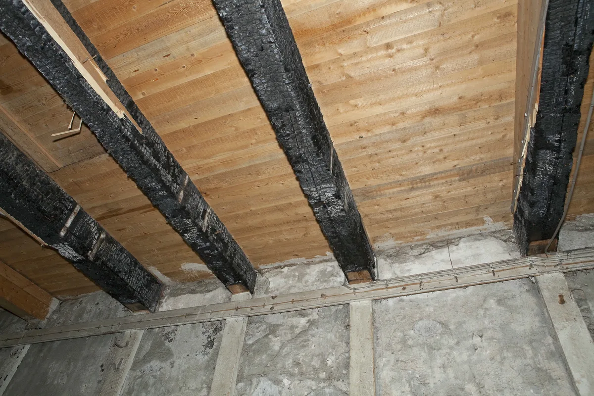 Brandschade aan houten dakbalken in interieur huurwoning — huurdersaansprakelijkheid bij brand