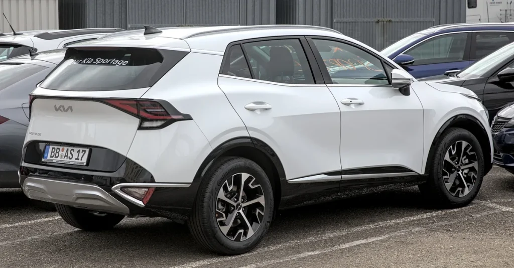 Witte Kia Sportage NQ5 SUV gezien van achteren op een parkeerplaats
